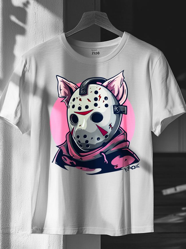 White T-shirt on a hanger featuring a character with a pale hockey mask, black holes, red markings, cartoon pig ears, and a dark hoodie against a soft pink background.