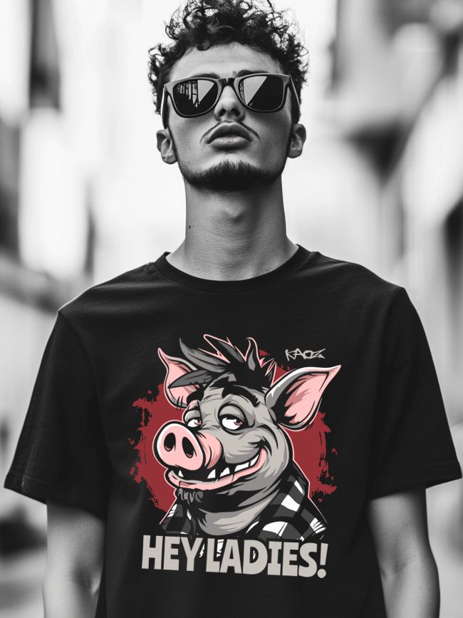 Young man wearing sunglasses and a black t-shirt with a colorful cartoon pig graphic and the text 'HEY LADIES!' in an urban setting