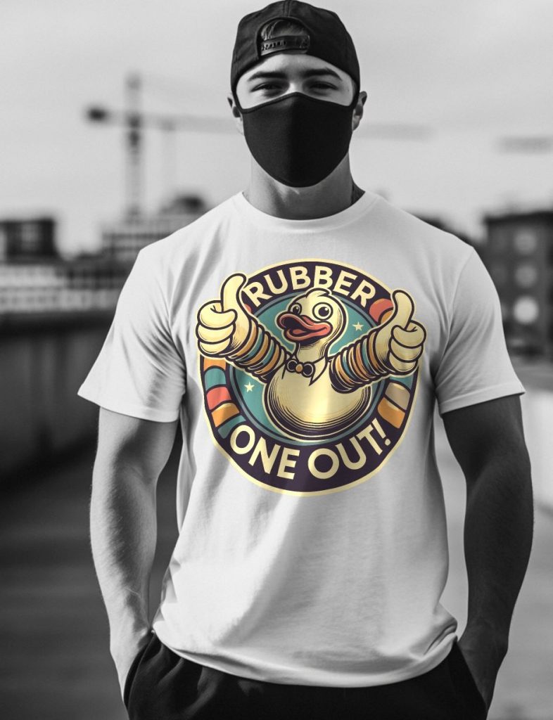 Young man wearing a white T-shirt with cartoon rubber duck graphic and thumbs-up, black face mask, and cap in an urban outdoor setting