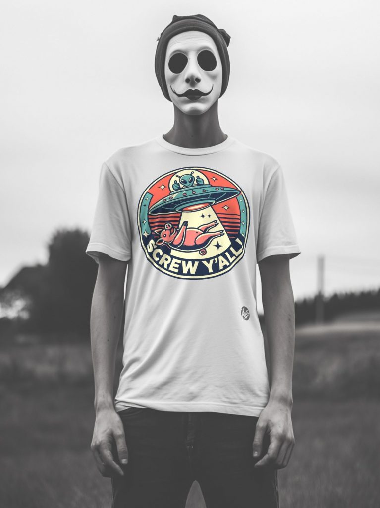 A person outdoors wearing a white t-shirt with a colorful graphic design featuring a UFO beaming up a cartoon pig, surrounded by the text 'SCREW Y’ALL', complemented by a painted mask with a stylized grin and exaggerated eyes.