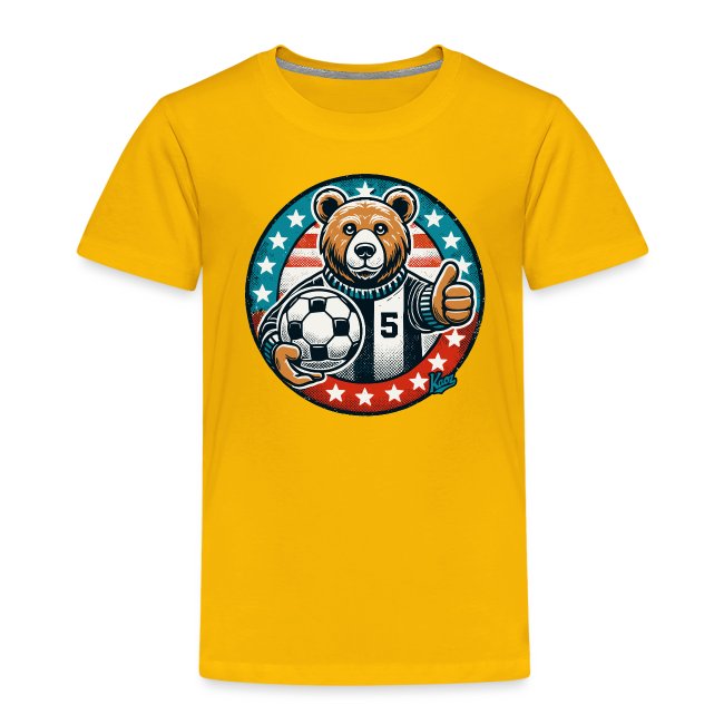 Bright yellow t-shirt featuring a playful bear character in a striped jersey holding a soccer ball and giving a thumbs-up, surrounded by red, white, and blue stars.