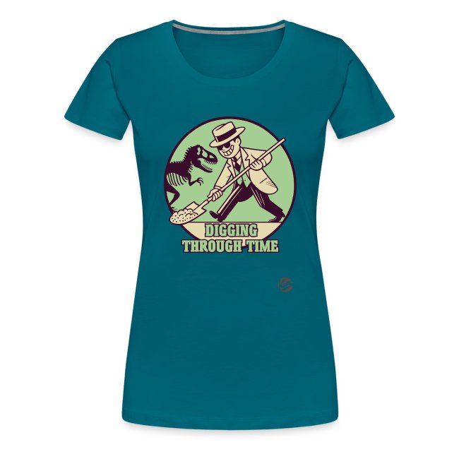A vibrant teal women's T-shirt featuring a playful character in a suit and hat holding a shovel, with a dinosaur silhouette in the background and bold text reading 'DIGGING THROUGH TIME'.