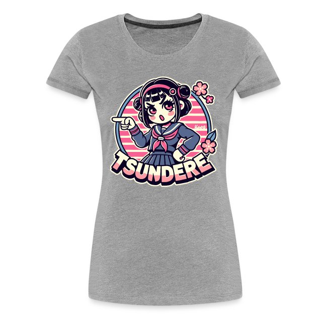 Gray t-shirt featuring a cartoon character with pigtails in a blue sailor suit, playfully pointing with a confident expression, framed by a retro pink background and cherry blossom accents, with the word 'TSUNDERE' below.