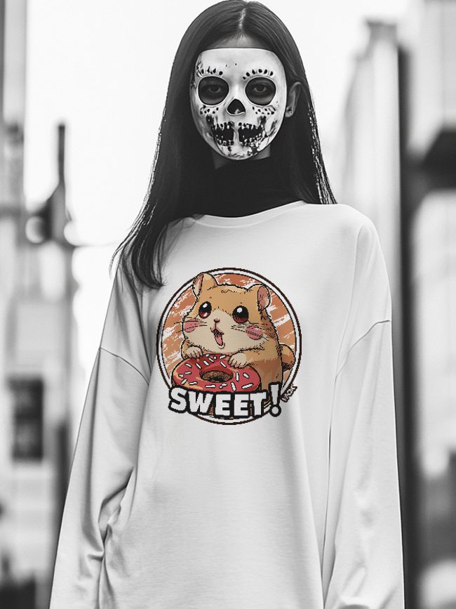 Young woman outdoors in white oversized sweatshirt with a playful hamster donut illustration and skull makeup against a softly blurred urban background.
