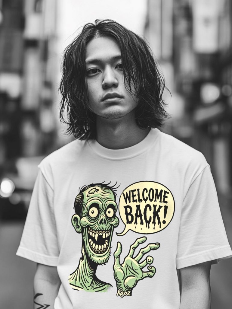 A young person with shoulder-length wavy hair wearing a white t-shirt featuring a colorful cartoon zombie with a speech bubble saying 'WELCOME BACK!' stands on a city street with blurred buildings in the background.